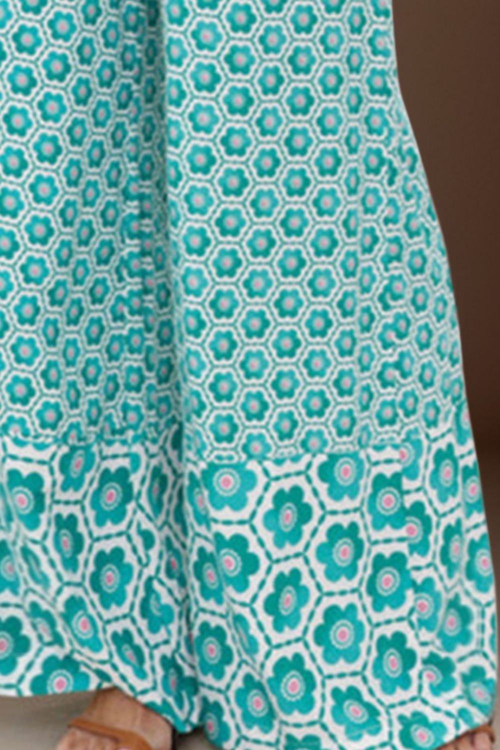 Turquoise pants with a vibrant floral pattern and flowy wide-leg design.