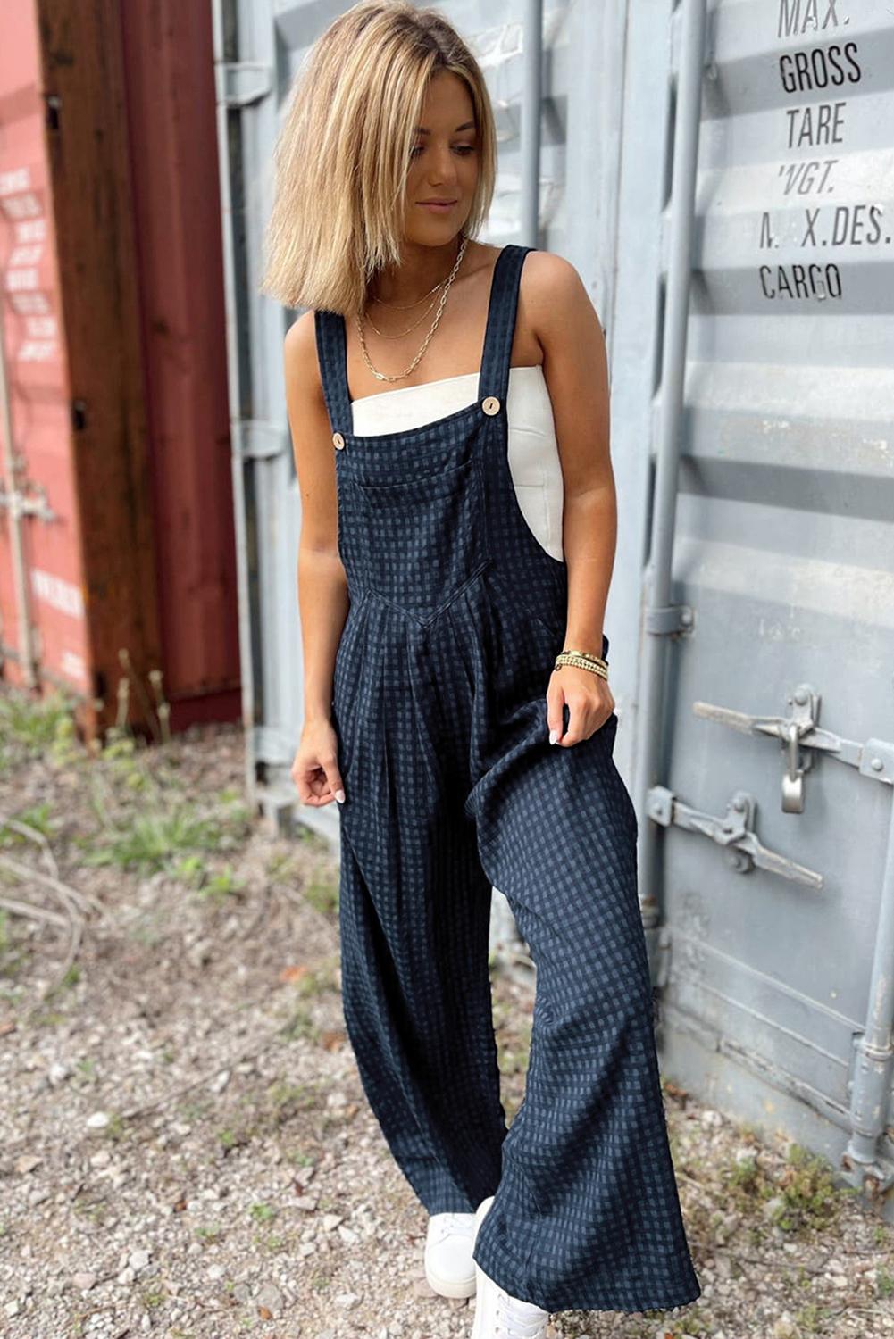 Women’s wide-leg plaid overalls featuring wide adjustable straps and a front pocket.
