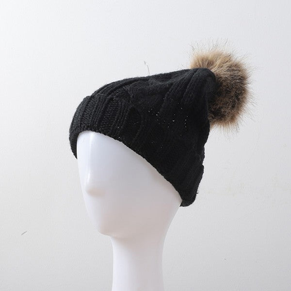 Soft black cable knit beanie with luxurious fur pom accent

