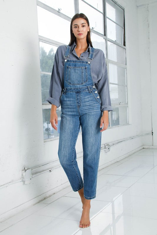 Women’s denim overalls featuring side button closure and mom-fit style.
