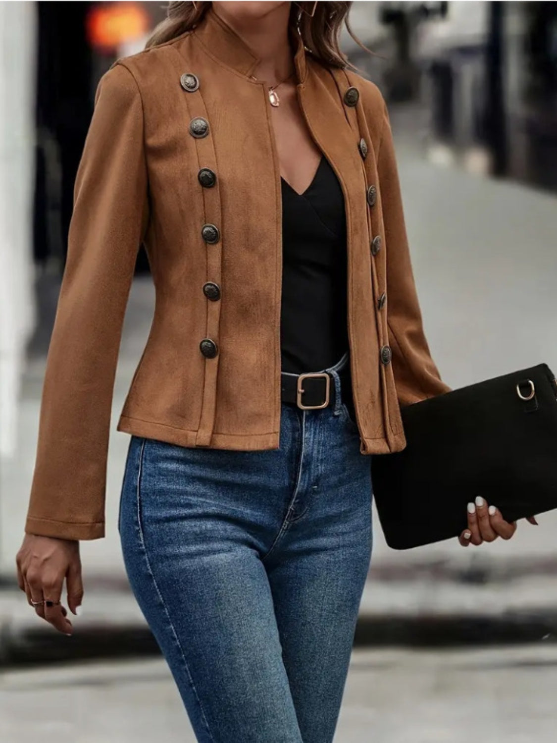 A woman wearing a chic brown mock neck jacket with double-button detailing.
