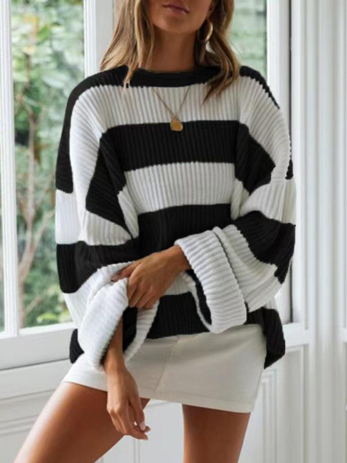 Classic black and white striped sweater for a versatile, everyday look.
