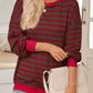 Woman in a brown striped oversized pullover styled with shorts.
