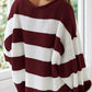 Cozy burgundy striped sweater with bold white stripes for a trendy look.
