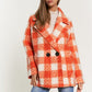 Front view of an orange plaid boucle coat for women, showcasing a long, tailored fit.
