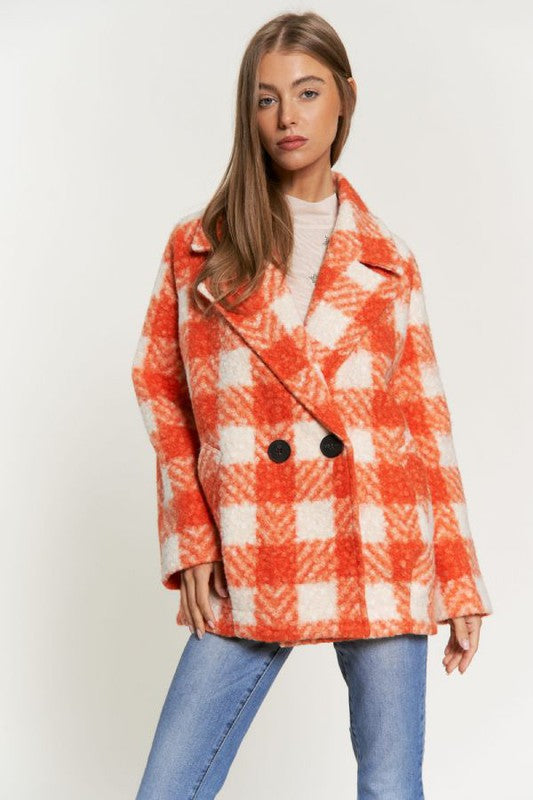 Front view of an orange plaid boucle coat for women, showcasing a long, tailored fit.
