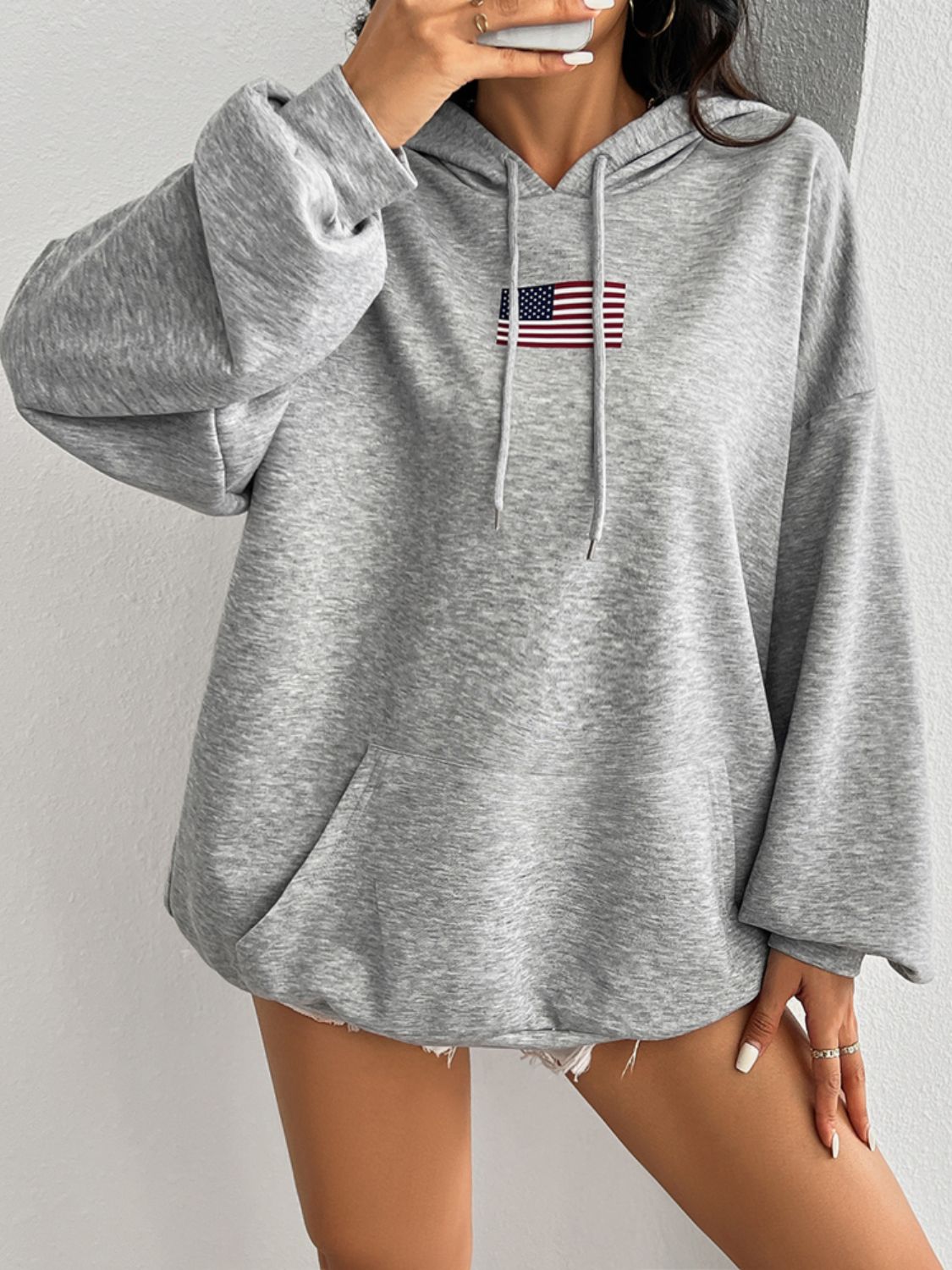 Soft gray hoodie featuring a small American flag on the chest.
