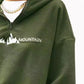 Soft green fleece pullover with mountain graphic and half-zip design.
