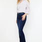 Women’s slim flare jeans paired with a white blouse and heels.
