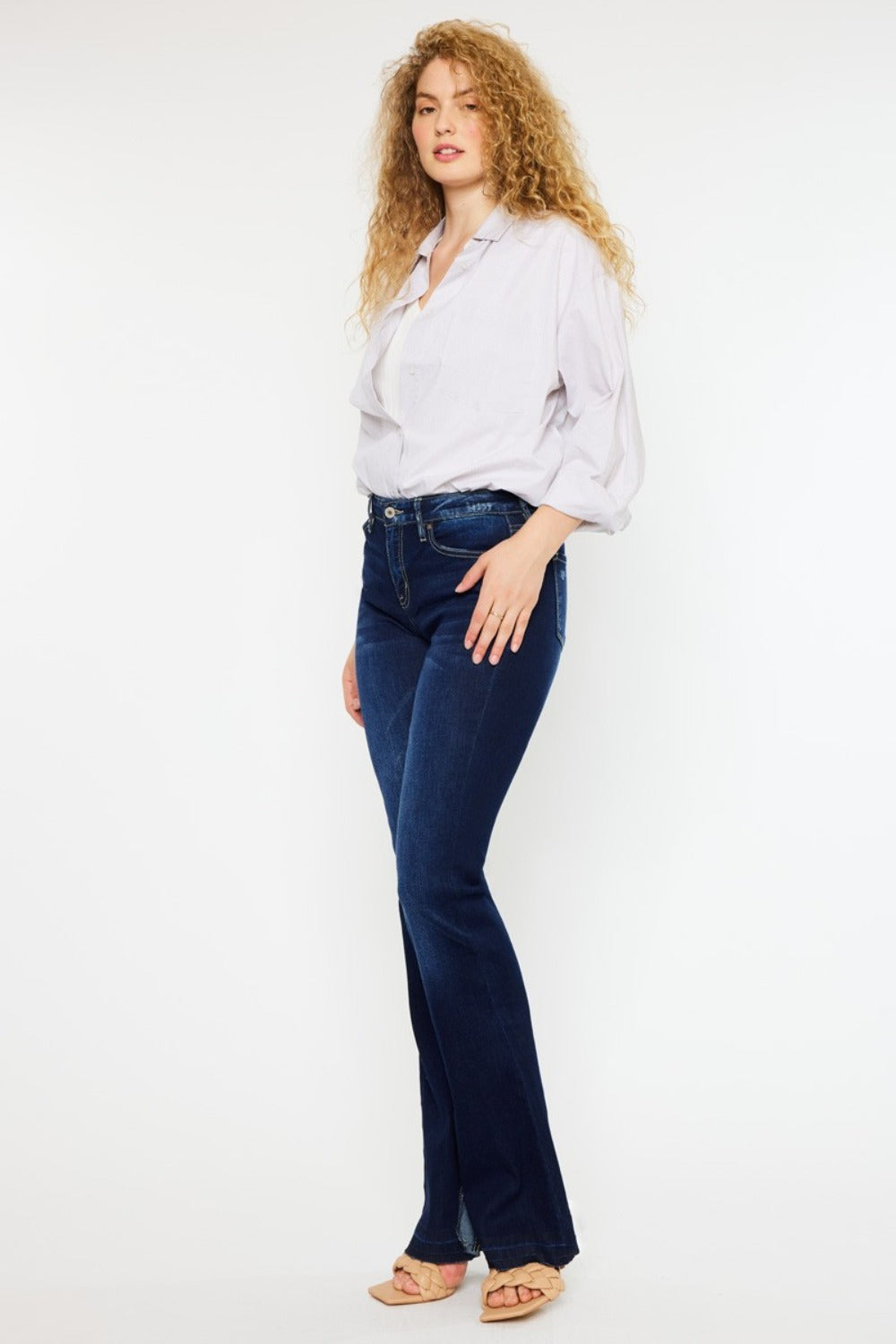 Women’s slim flare jeans paired with a white blouse and heels.
