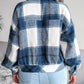 Back view of a blue plaid collared long sleeve jacket for women.
