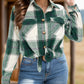 Green plaid button-up shirt paired with a casual outfit.
