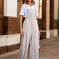 Women’s pocketed wide-leg overalls styled with a white t-shirt and sandals.
