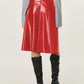 Bold red leather skirt in an A-line style, ideal for day-to-night outfits.
