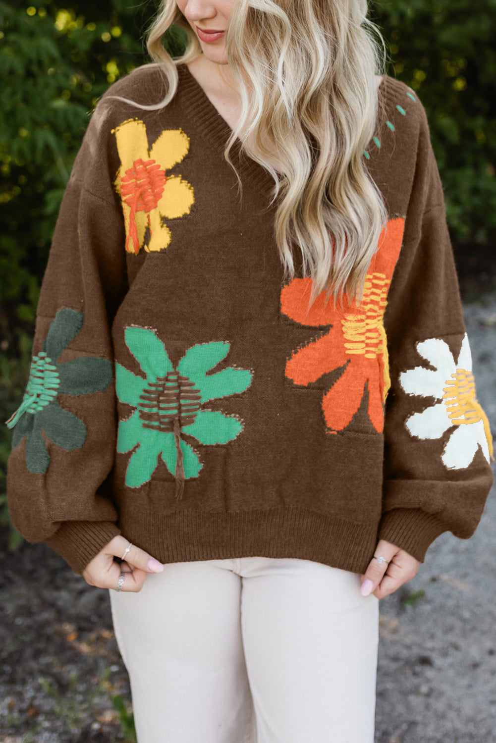 Cozy brown sweater with 60s-inspired flowers, styled with jeans.
