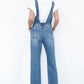 Medium-wash 100% cotton straight-leg denim overalls styled with a white tee.
