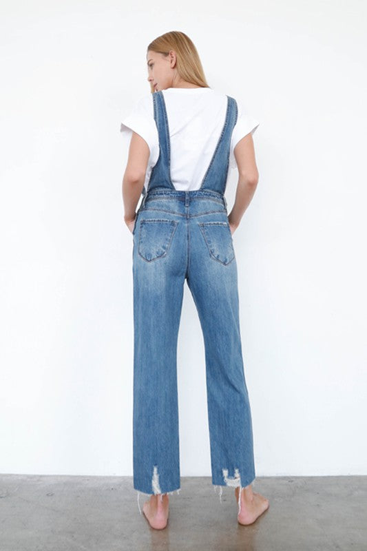 Medium-wash 100% cotton straight-leg denim overalls styled with a white tee.
