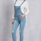 Women’s trendy light washed denim overalls with mid-waist design and ripped knees.
