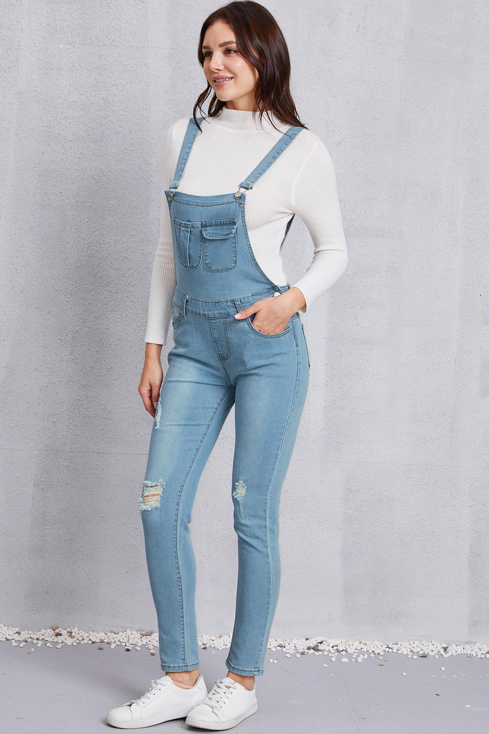 Women’s trendy light washed denim overalls with mid-waist design and ripped knees.
