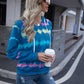 Blue tie-dye hoodie with a relaxed fit and cozy hood, styled with ripped jeans for a casual weekend outfit.
