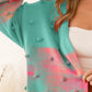 Comfortable pink and teal sweater cardigan with eye-catching pom-poms
