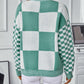 Trendy turquoise checkerboard sweater with bold, contrasting patterns.
