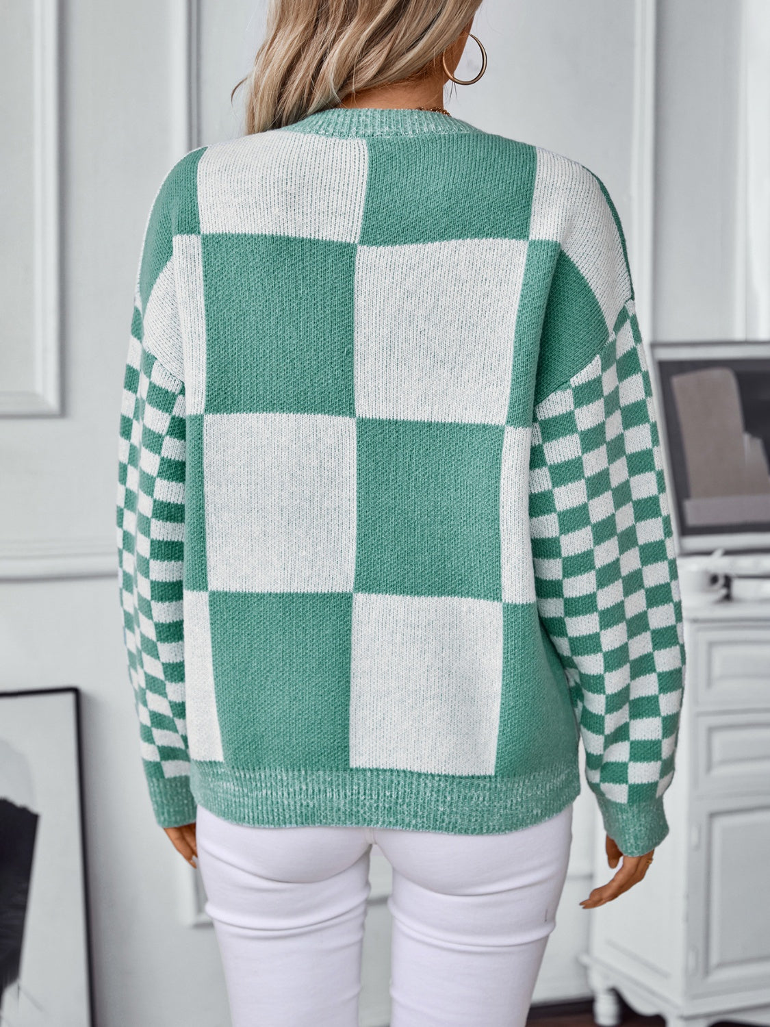 Trendy turquoise checkerboard sweater with bold, contrasting patterns.
