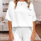 Women's white satin lounge set with coordinating top and shorts.
