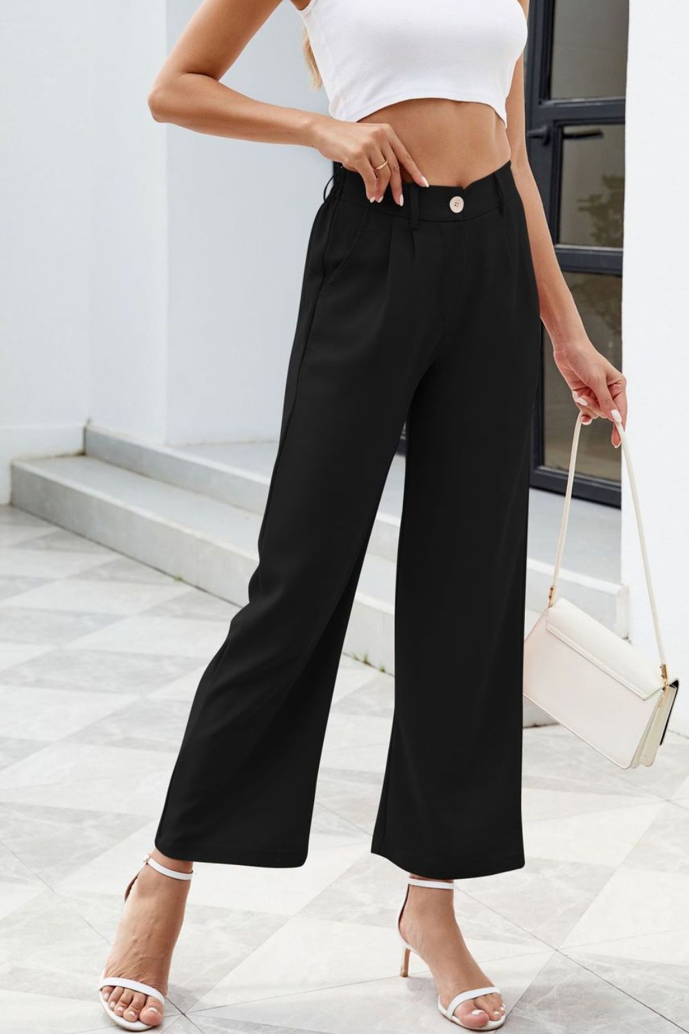 Black high-waisted trousers styled with heels for a night out
