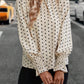 Classic polka dot blouse with feminine ruffled cuffs, styled for a chic, vintage-inspired look.
