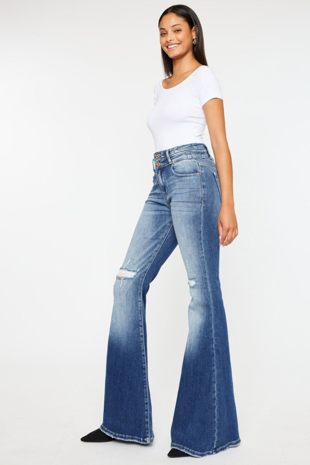 Women's high-rise flare jeans in medium wash with a wide waistband and distressed finish.
