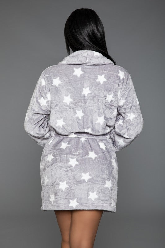 Woman in a gray star-patterned plush robe, showcasing the soft fabric and loose fit.
