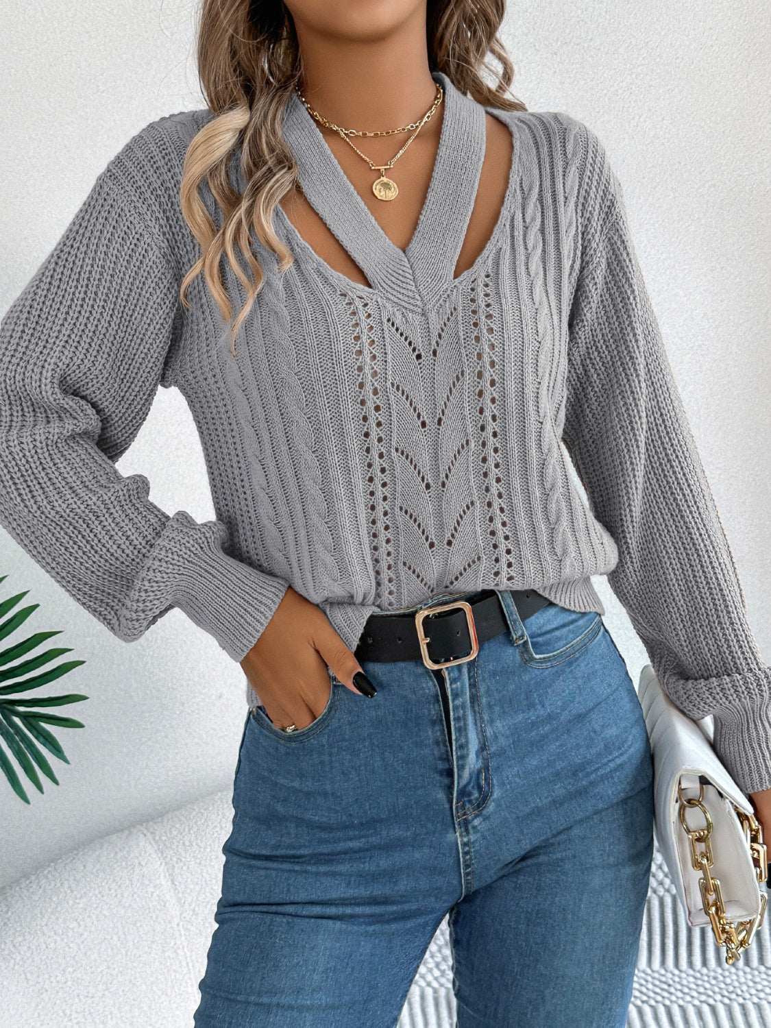 Woman in gray cutout cable knit sweater for a chic fall look