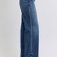 Medium wash raw hem jeans styled with red heels
