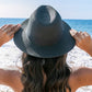 Trendy straw fedora with black detailing, ideal for summer sun protection.
