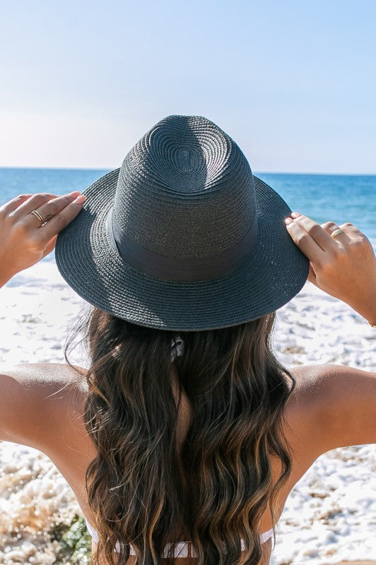 Trendy straw fedora with black detailing, ideal for summer sun protection.
