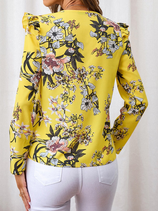 Floral V-neck blouse with ruffled shoulders in a bright yellow fabric, perfect for a casual day out.
